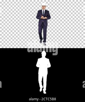 Engineer in suit and helmet walking and writing notes in notepad Stock Photo