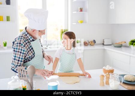 Portrait of nice cheerful cheery grey-haired grandpa grandchild kneading making domestic dough baking dessert cookies sweet snack leisure in modern Stock Photo