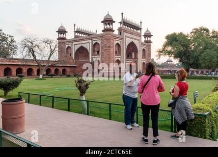 Agra, Uttar Pradesh, India - March 2019: A tour guide with two European tourists sightseeing at the ancient Taj Mahal. Stock Photo