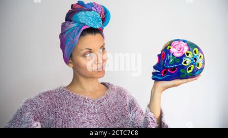Day of The Dead. The woman holds it in her hand decorated colorful  skull. Calavera Catrina. Dia de los muertos.