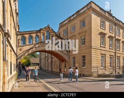 OXFORD CITY ENGLAND PEOPLE IN NEW COLLEGE LANE WITH HERTFORD BRIDGE ALSO CALLED THE BRIDGE OF SIGHS Stock Photo