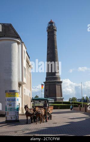 Horse drawn carriage with the new lighthouse of Borkum Island in the background, Lower Saxony, Germany, Europe. Stock Photo