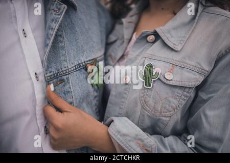 man and woman dressed in white wedding clothes denim blue jackets Stock Photo