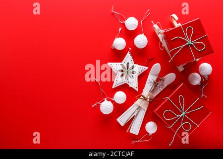 Top view on a red background with red gift boxes, star ornaments and small wooden skis and sleds for Christmas holidays Stock Photo