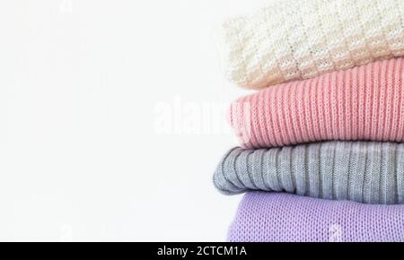 Stack of cozy knitted autumn or winter sweaters isolated on white background with copy space Stock Photo