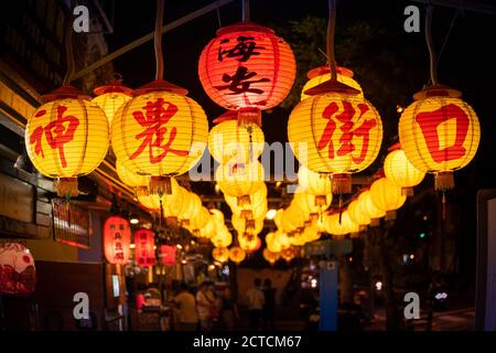 Lanterns hung up in street in Tainan. With the name of the street labeling on them. The name labeling on the red lan Stock Photo