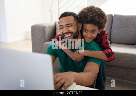 Father and son using laptop at home Stock Photo