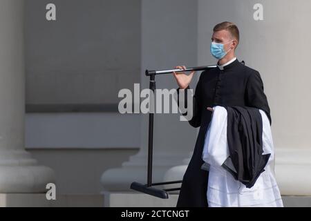 Young priest with protective face mask going to the church to celebrate mass during second wave of Covid or Coronavirus outbreak Stock Photo