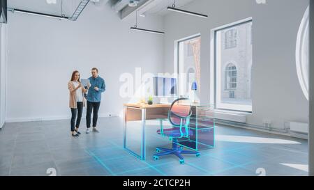 In Empty New Office: Female Interior Designer and Male Office Architect Talk, Use Augmented Reality Software on Digital Tablet Computer to Choose and Stock Photo