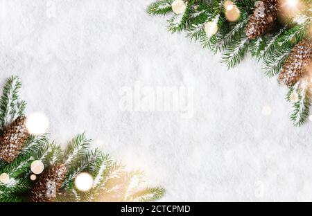 Christmas background, green pine branches, cones on snow background and light. Creative composition with border and copy space, top view. New Year's, Stock Photo