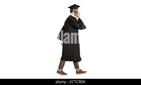 Graduating student starts walking and making a call on white bac Stock Photo