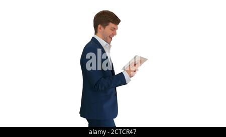 Smiling businessman using digital tablet while walking on white Stock Photo