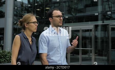 The business man and a woman walking and talking along the build Stock Photo