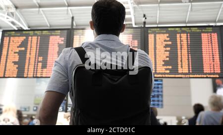 Businessman checking flight information at airport. Stock Photo