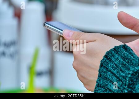 Person holds a smartphone and uses it. Stock Photo