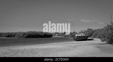 Grayscale shot of the boat on the sandy beach Stock Photo