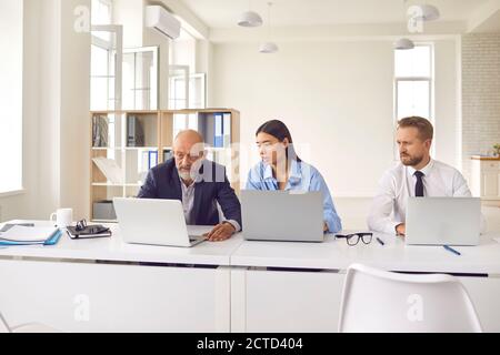 Team of tense businesspeople using computers, analyzing stock market data or having software problem Stock Photo