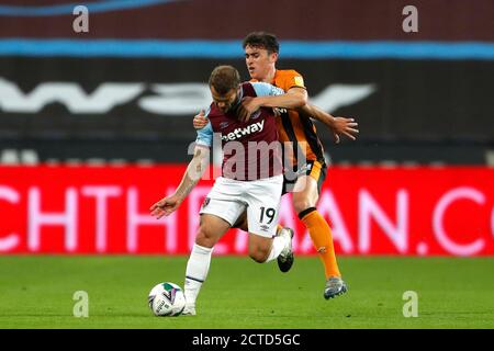 West Ham United's Jack Wilshere (left) and Hull City's Callum Jones battle for the ball during the Carabao Cup third round match at the London Stadium. Stock Photo