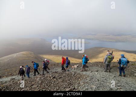 A walking group heading down from the Munro Ben More on the Island of Mull towards Loch na Keal Stock Photo