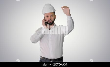 Architect talking by the phone while walking on gradient backgro Stock Photo