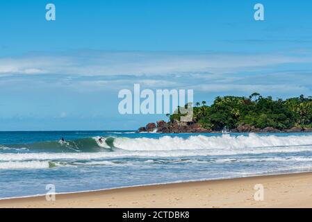 Two surfers  on wave in brazilian beach shore Stock Photo