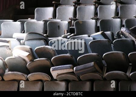 Pile of old worn seats awaiting renovation in historic vintage movie theater building. Stock Photo