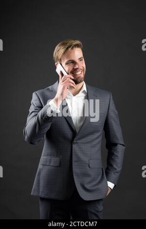 Business communication and modern life. digital marketing and new technology. Manager with beard on happy face speak on phone. Man in formal outfit with mobile phone. Businessman or ceo fashion. Stock Photo