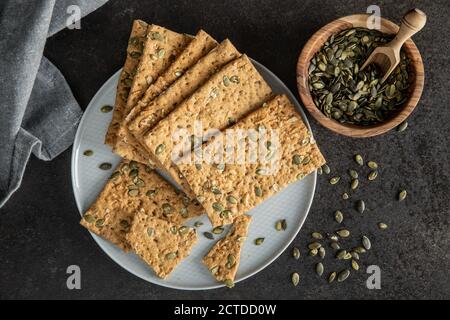 The  crispy bread with pumpkin seeds. Knackebrot on plate. Top view. Stock Photo