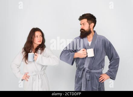 family life and routine. couple has problems in relationship. warm up our relations. tea time at home. morning couple drink coffee. woman and hipster man coffee cup. hard morning. Again in bad mood. Stock Photo