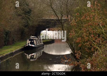 A canal boat by a bridge in this photo taken along the Grand Union canal in Buckinghamshire Stock Photo