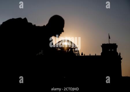 Berlin, Germany. 22nd Sep, 2020. A cyclist passes the Reichstag building as the sun sets behind the Reichstag dome. Credit: Christoph Soeder/dpa/Alamy Live News