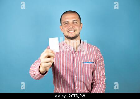 Russian business man over blue background showing a white card. Stock Photo