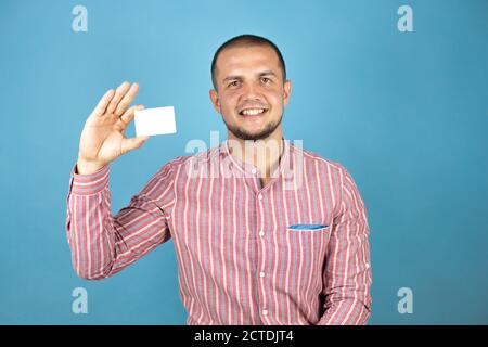 Russian business man over blue background showing a white card. Stock Photo