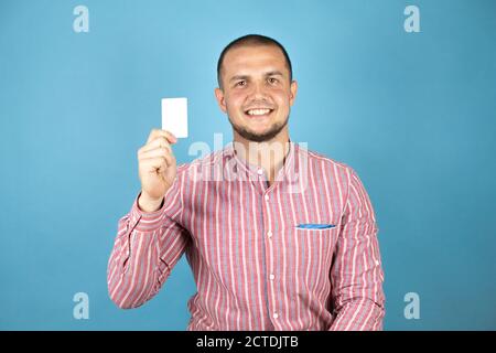 Russian business man over blue background showing a white card. Stock Photo