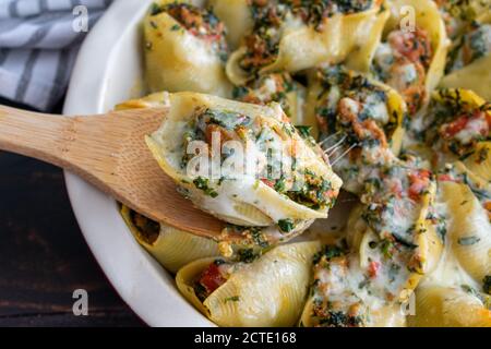 Sausage Stuffed Shells with Spinach: Jumbo pasta shells stuffed with Italian sausage, tomatoes, spinach, and ricotta cheese Stock Photo