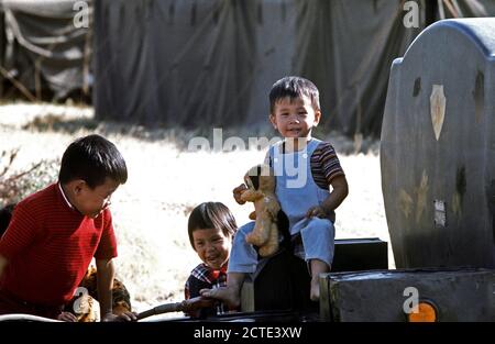 1975 - Children play on a piece of equipment at a temporary housing facility for Vietnamese refugees at Camp Pendleton Stock Photo