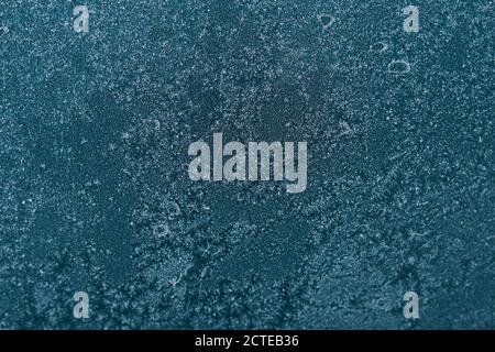 Winter ice texture on the frozen window. Christmas or New year background. Type of glass at low temperatures. Stock Photo