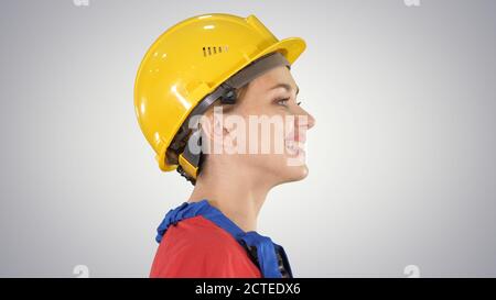 The young woman engineer with yellow safety helmet walking and s Stock Photo