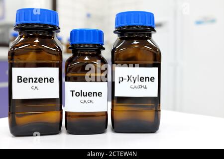 Selective focus of benzene, toluene and xylene liquid chemical compound in glass amber bottle inside a chemistry laboratory with copy space. BTX aromatic hydrocarbons. Stock Photo