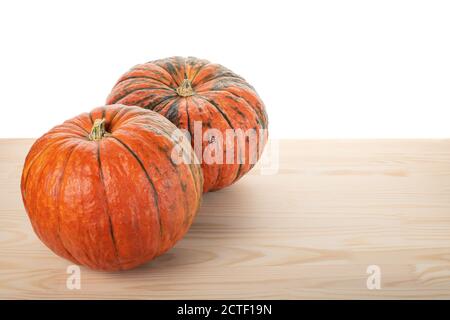 two pumpkins on a wooden table, white background. Two ripe organic pumpkins. Thanksgiving background. copyspace Stock Photo