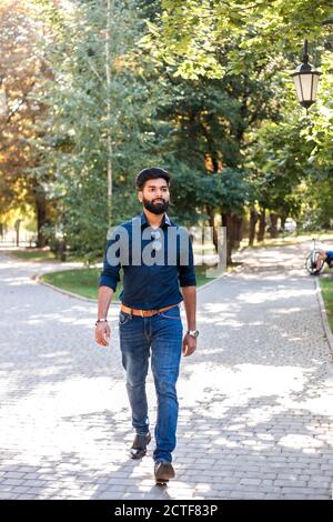 Young Indian man walking in the street. Stock Photo
