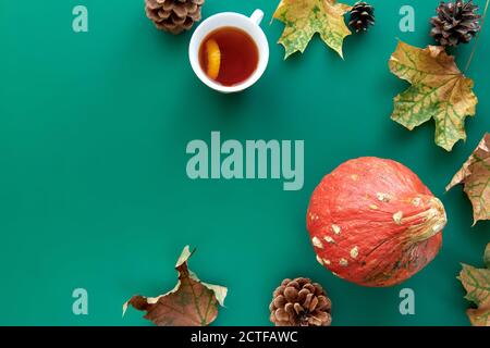 Autumn composition. Frame made of Pumpkins,dried leaves, pine cones and tes cup background. Template autumn, fall, halloween, harvest thanksgiving Stock Photo