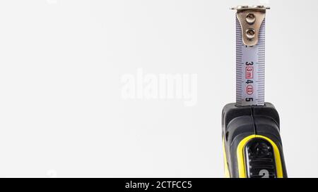 Measuring roulette yellow black on a white background banner with space for text. A construction tool Stock Photo