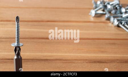 A screwdriver and self-cutters on a brown wooden background. Building tools to repair the house Stock Photo