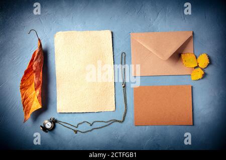 Autumn stationery mockup. Craft greeting cards or invitations with an envelope, overhead flat lay shot with fall leaves Stock Photo
