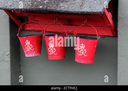 Rack of vintage world war two fire buckets at vintage air museum. Stock Photo