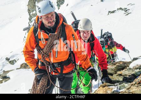 Mountain guide leading a group of alpinists up to Monte Rosa Glaciers Stock Photo