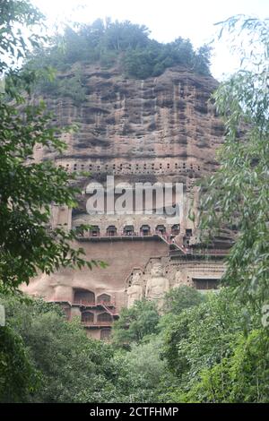 Sculptures of Buddhas are seen on the half of the mountain at the Maijishan Grottoes, a series of 194 caves cut in the side of the hill of Majishan, T Stock Photo