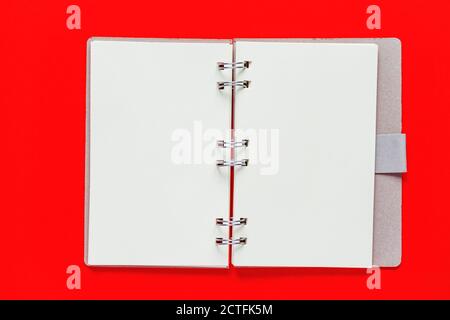 Clean spiral note book for notes and messages on red background. Minimal business flat lay Stock Photo