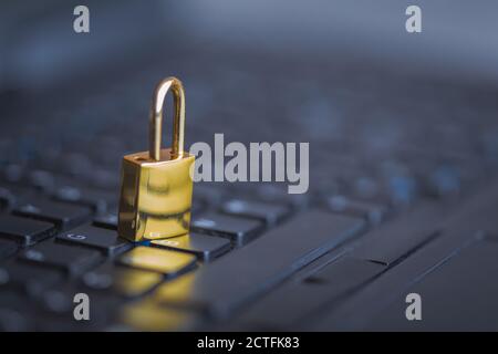 Background image of golden metal lock on keyboard, computer security Stock Photo